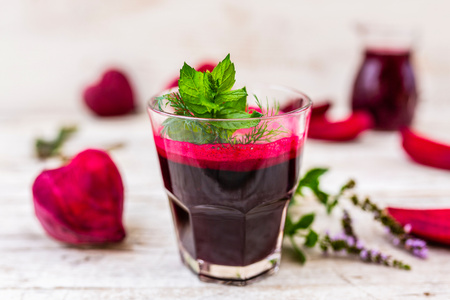 Ein Glas Bio-Erdbeerkonfitüre vor Erdbeeren, Aufschrift: "aus hofeigenen Früchten", "aus der Hofküche".