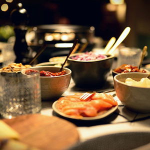  Ein Tisch mit verschiedenen Schüsseln voller Zutaten für Raclette.