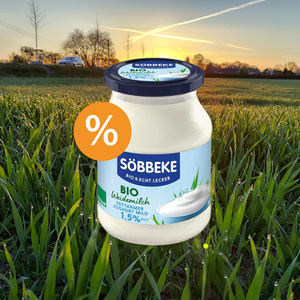 KI generiert: Ein Glas Söbbeke Bio-Joghurt vor einem Feld bei Sonnenuntergang. Text: "BIO Weidemilch Joghurt mild 1,5% Fett".
