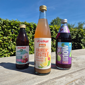 KI generiert: Ein Glas Söbbeke Bio-Joghurt vor einem Feld bei Sonnenuntergang. Text: "BIO Weidemilch Joghurt mild 1,5% Fett".