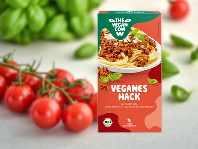 Ein Glas Bio-Erdbeerkonfitüre vor Erdbeeren, Aufschrift: "aus hofeigenen Früchten", "aus der Hofküche".