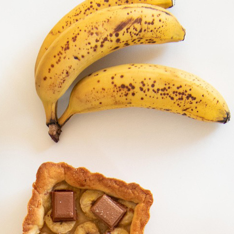 KI generiert: Das Bild zeigt eine stilisierte Illustration einer gelben Karotte mit grünem Blattwerk auf einem hellgrünen Hintergrund. Der Hauptinhalt ist die minimalistische Darstellung der Karotte.