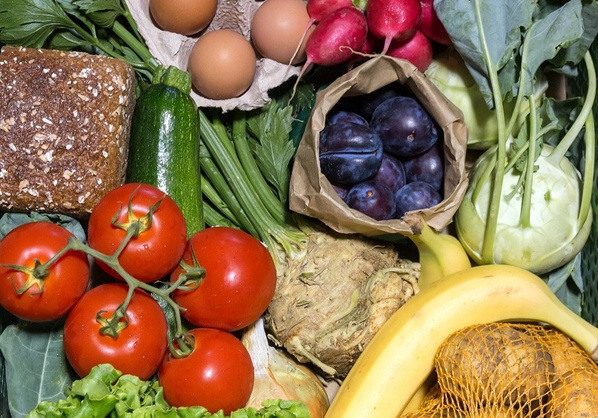 Frisches Obst, Gemüse, Eier und Brot in einer bunten Auswahl.