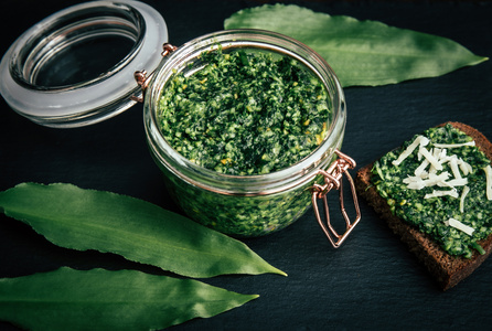 Korb mit frischem Bärlauch auf dunklem Hintergrund.