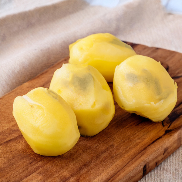 KI generiert: Das Bild zeigt fünf Kartoffeln, von denen einige grüne Stellen aufweisen, auf einem Stoffuntergrund. Die Hauptinhalte sind die Kartoffeln und deren unterschiedliche Farben.