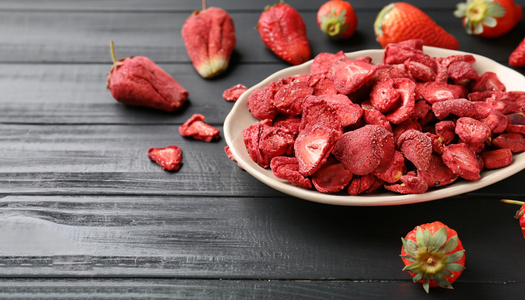 KI generiert: Eine Schale mit Joghurt, Himbeeren, Chiasamen, Müsli und Minze auf hellem Holz, daneben ein Löffel.