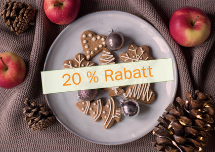 Zimtsterne, Zimtstangen, Tannenzapfen und Walnüsse auf Holztisch.