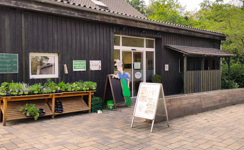  Ein weißes Gebäude mit grünem Garten und blauem Himmel im Hintergrund.