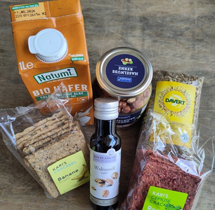 Frisches Gemüse und Hülsenfrüchte mit Ölflasche auf einem Holztisch.